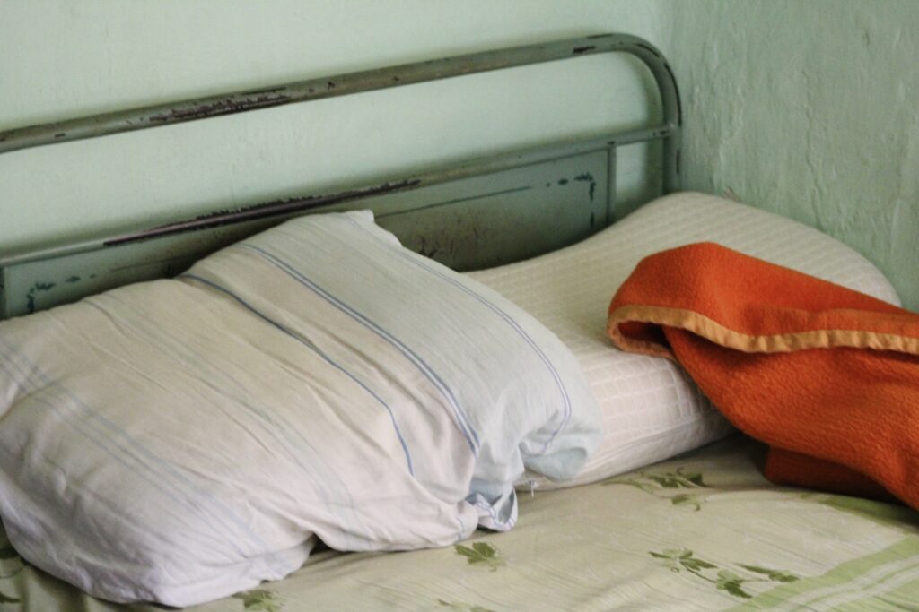A close-up photo of a bed with pillows and a blanket.